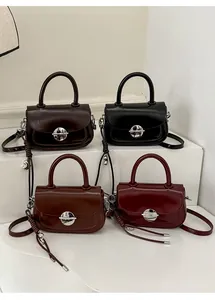 Detail showing various colors of small square handbags with circular metal swivel locks