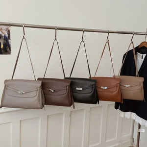 Detail view of five retro leather tote bags in various colors on a display rack