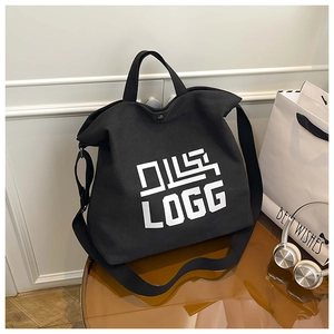 Detail of black canvas tote bag showing heavy-duty fabric texture and metal snap button