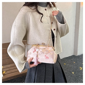 Close-up of pink floral silk satin clutch with gold ring handle and elegant tassel