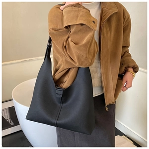 Detail der schwarzen Leder-Shopper-Tasche mit Markenlogo und breitem Schultergurt