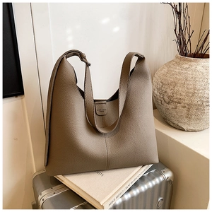 Detail einer braunen Shopper-Tasche aus Narbenleder mit vertikaler Naht auf Koffer