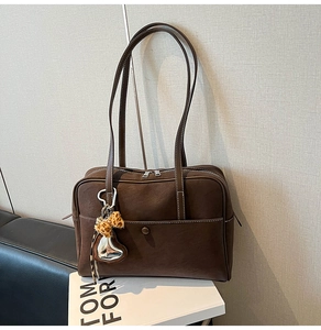 Detail view of dark coffee tote bag with silver zipper and leopard heart charm