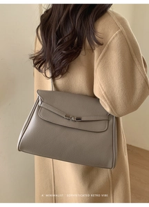Rear view of model in camel coat carrying the retro grey leather tote bag for daily commute