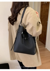 Detail der minimalistischen schwarzen Eimertasche aus Kieselleder mit Metallschnalle