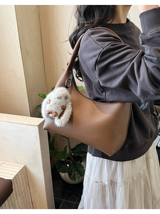 Brown litchi grain leather hobo bag with cute white plush rabbit charm on shoulder