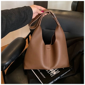 Nahaufnahme der braunen Ledertasche mit Lychee-Maserung und geprägtem Markenlogo-Detail