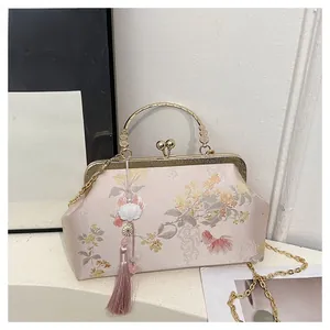 Detail of pink satin doctor bag with floral embroidery and golden metal kiss lock