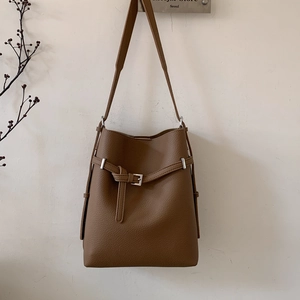 Detailansicht der braunen Bucket Bag mit Litschiprägung, Metallschnalle und Riemendetails