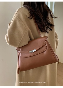 Detail of vintage brown lychee grain leather tote bag with silver metal twist lock buckle