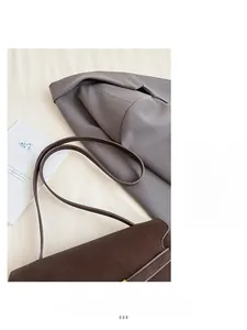 Detail view of the deep brown matte leather texture and stitching on the flap shoulder bag
