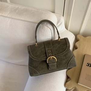 Close-up of retro olive green suede handbag with gold buckle and white stitching detail