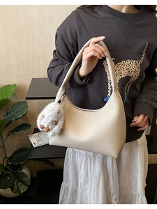 Chic beige pebbled leather hobo bag featuring a cute white plush bunny charm detail