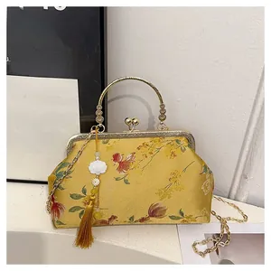 Detailed embroidery on yellow silk handbag with floral patterns and retro metal clasp