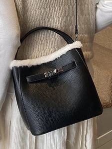 Elegant black leather bucket bag with white faux fur trim and silver metallic twist lock