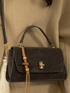 Minimalist dark grey flap handbag with gold twist lock and boho tassel wood beads
