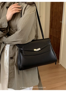 Detail of classic black lychee grain leather tote with silver metal twist-lock buckle