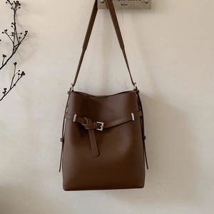 Detail der dunkelbraunen Beuteltasche aus Leder mit Lychee-Narbung und Metallschnalle
