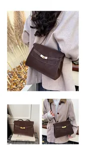 Detail of vintage brown leather tote bag with gold hardware buckle for daily commute