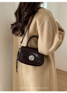 Detailed side view of vintage dark brown leather crossbody bag with silver buckle