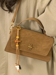 Brown suede handbag with gold rotating lock and ethnic tassel pendant for women