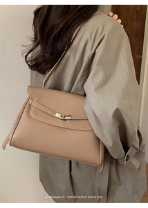 Detailed view of khaki pebbled leather tote bag with elegant metallic twist lock closure