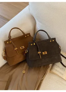 Detail view of retro caramel and charcoal bags with gold hardware and key charms