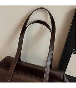 Close-up of sleek long shoulder strap and dark brown wax leather bag construction