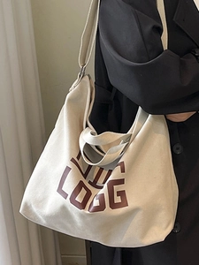 Modern off-white canvas tote bag with letter print and adjustable shoulder strap