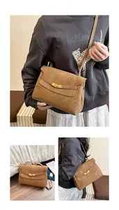 Detail of vintage brown leather crossbody bag with metallic clasp and textured matte finish