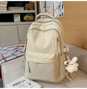 Détail du sac à dos scolaire crème avec imprimé étoiles, poche avant et peluche lapin