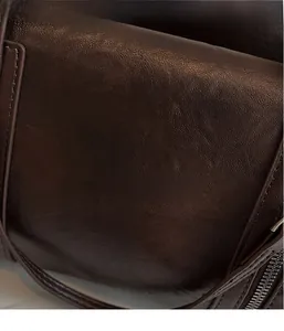 Close-up of deep brown leather texture and metal zipper on high-quality Boston bag