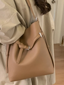 Schicke braune Beuteltasche aus Leder mit Lychee-Muster und silberner Schnalle am Model