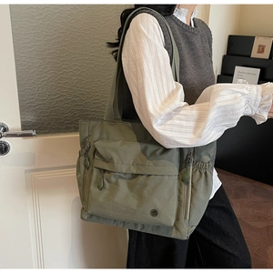 Detailansicht der großen armeegrünen Tragetasche mit vielen Taschen und Kordelzug