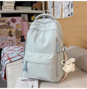 Vue détaillée du sac à dos vert menthe avec imprimés étoiles, zips et breloque lapin