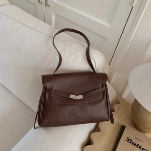 Close-up of deep brown lychee grain leather tote bag with silver metal twist lock