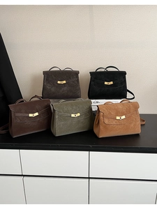 Detailed view of structured trapezoid handbags in five colors with gold turn-lock clasps