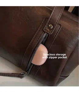 Detail view of deep brown leather underarm bag featuring functional zipper pocket storage