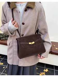 Macro detail of retro brown crossbody bag with gold buckle on a wool coat outfit