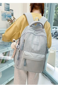 Détail du sac à dos scolaire gris-bleu à étoiles avec pendentif lapin et compartiments