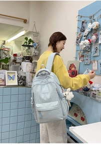 Vue détaillée d'un sac à dos bleu clair à motifs d'étoiles avec un pendentif lapin
