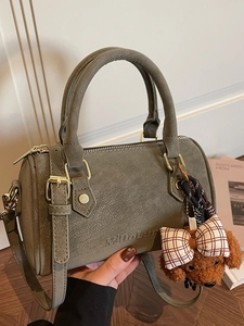 Chic grayish-green Boston bag with a cylinder shape, top handles, and a cute puppy pendant