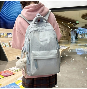 Sac à dos scolaire bleu clair avec motifs d'étoiles et détail de pendentif chien