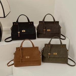 Detailed view of retro handbags in four matte colors with gold twist locks and key charms