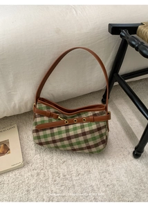 Dettaglio della trama a quadri vintage con cinturini in pelle premium e fibbie in metallo