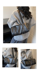 Detailed view of black Boston shoulder bag with vertical zippers and heart charm detail