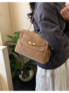 Side view of a vintage caramel brown tote bag with leather straps and metal turn-lock