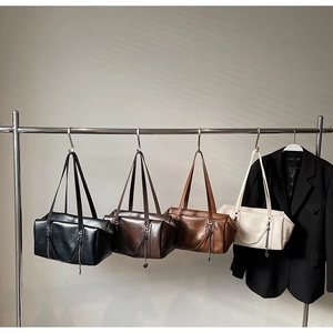 Four colors of vintage Boston bags hanging on display with stylish chain details