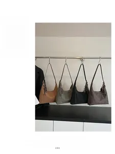 Detail showing four retro hobo bags in caramel, green, black and brown with metal charms