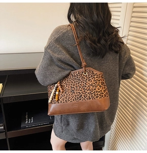 Detail showing leopard print contrast tote with beaded tassel and knotted shoulder strap